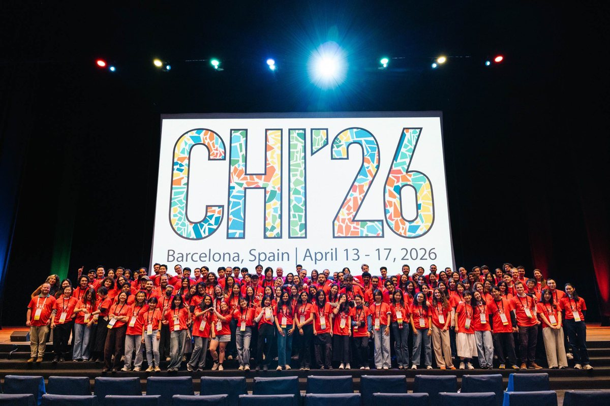 The CHI 2026 student volunteers on stage in Barcelona, in red T-shirts