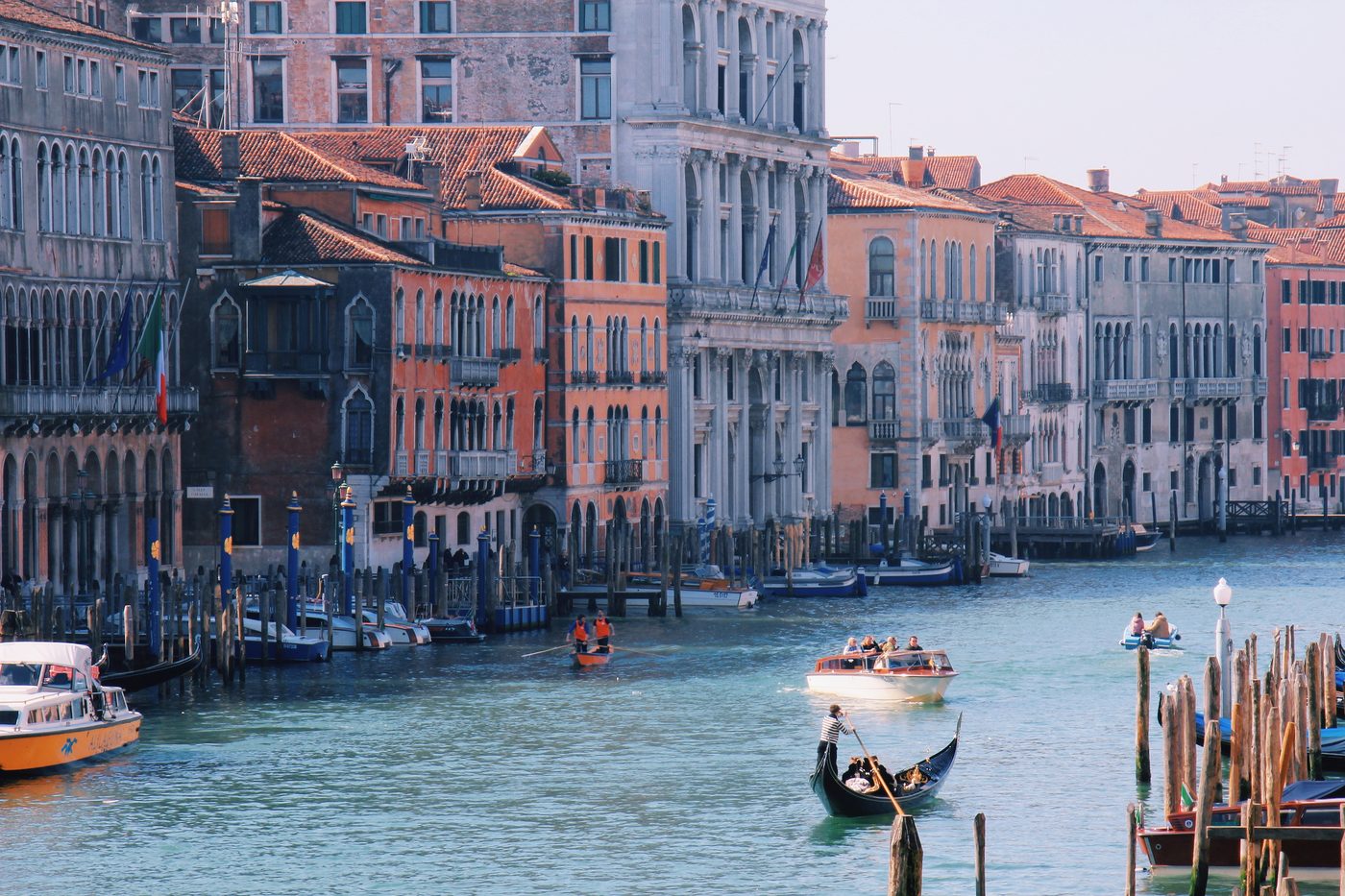 A gondola and water taxis on the Grand Canal, lined with pastel palazzi